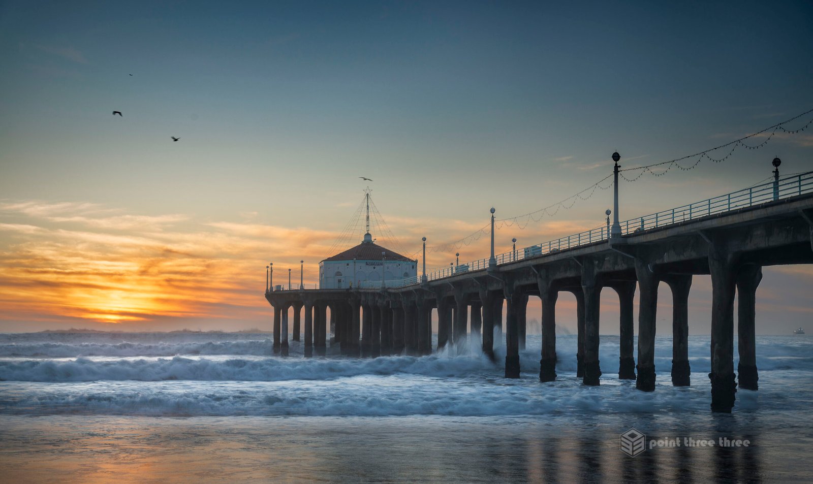 Sunset and crashing waves at Manhattan Beach Pier, Los Angeles, California