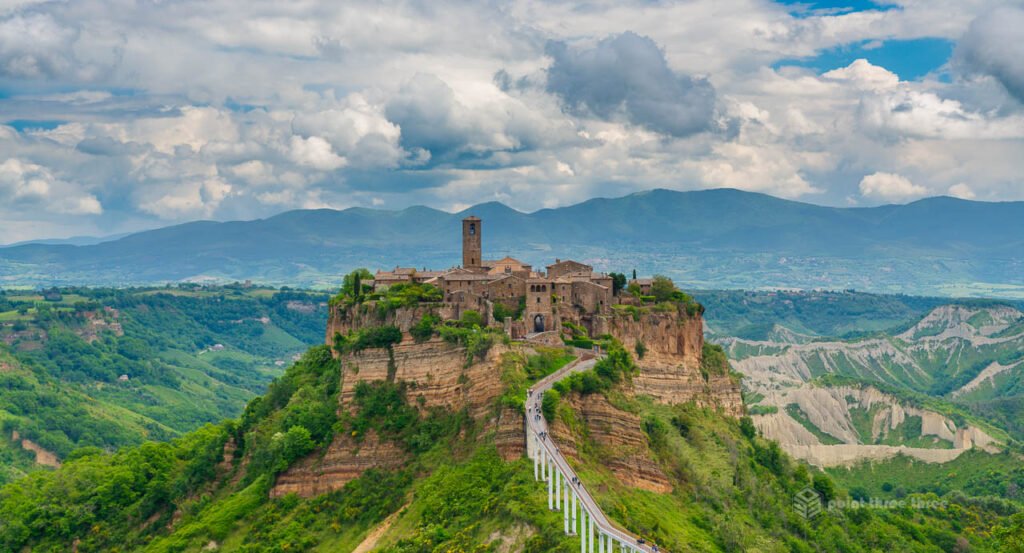 Panoramic view of Civita di Bagnoregio, the medieval village on a crumbling volcanic plateau connected by a long pedestrian bridge in Lazio, Italy.