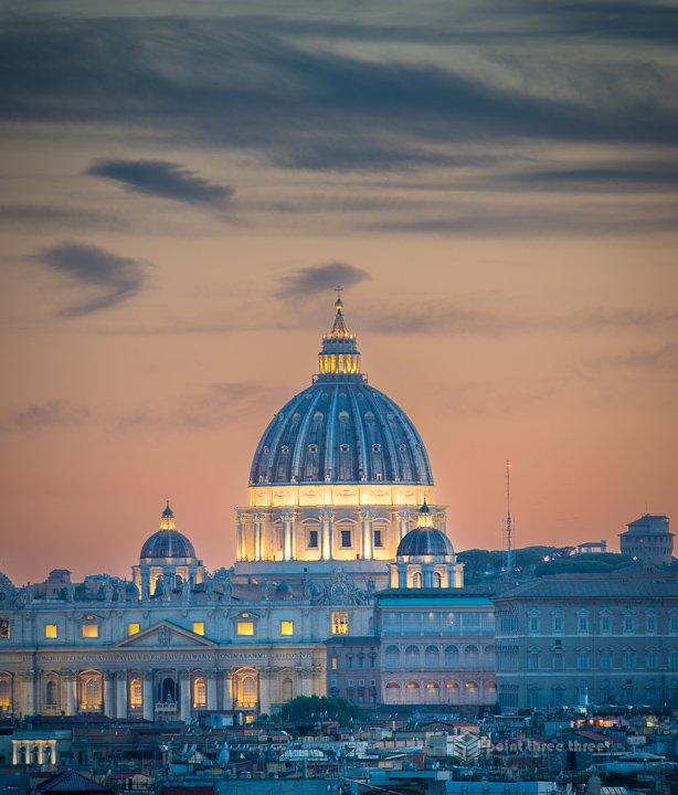 Aerial sunset view of the Rome skyline from the top of the Spanish Steps, featuring the dome of St. Peter's Basilica